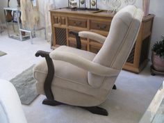 a reclining chair sitting on top of a white carpeted floor next to a dresser