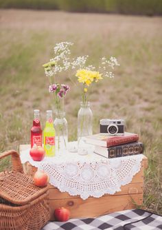 a picnic table with flowers, books and drinks