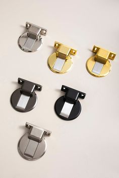 four different types of door handles on a white surface with black, gold and silver knobs