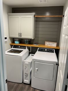 a washer and dryer in a small laundry room with cabinets on the wall