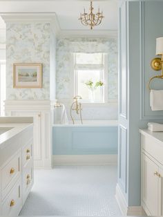 a bath room with a tub a sink and a chandelier on the wall