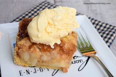 a piece of pie with ice cream on top and a fork sitting next to it