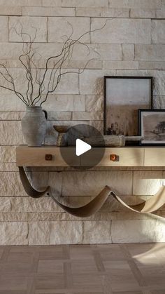 a shelf with some pictures on it next to a vase filled with flowers and plants