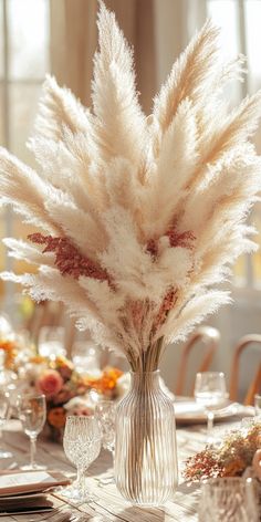 a vase filled with lots of white flowers sitting on top of a dining room table