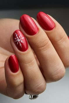 A simple yet elegant red nail design with a white snowflake on the ring finger, perfect for the holiday season. The glossy red finish adds a vibrant touch, while the snowflake art brings in the winter spirit. Red Nails With Snowflake, Nails With Snowflake Design, Red Nail Design, Christmas Snowflakes Nails, Snowflake Art, Gold Gel Nails, Red And White Nails, Ring Finger Nails, Red Gel Nails