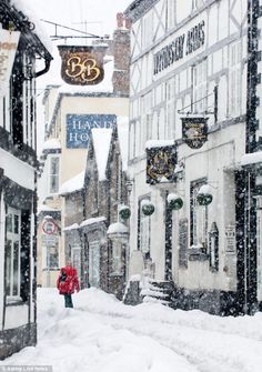 a woman walking down a snow covered street