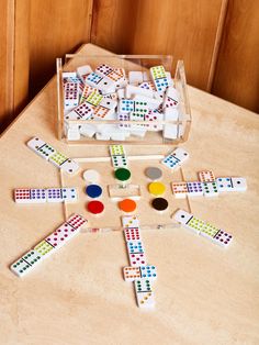 a wooden table topped with different colored dominos