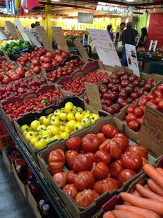 several boxes of tomatoes and other vegetables on display