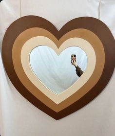 a heart shaped window with a person taking a photo