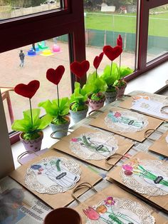 there are many cards on the table with flowers in vases next to each other