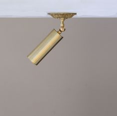 a gold colored light fixture with a white ceiling and grey walls in the back ground