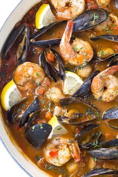 a bowl filled with seafood and mussels next to a red sign that says san francisco seafood clopino - style