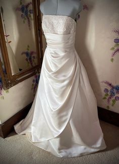 a wedding dress on display in front of a mirror