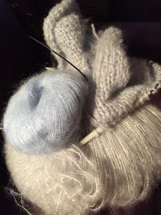 a skein of yarn sitting on top of a table next to a knitting needle