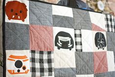 a person holding up a quilt with different designs on it