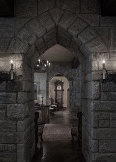 an archway leading to a living room with candles on the wall and furniture in the doorway