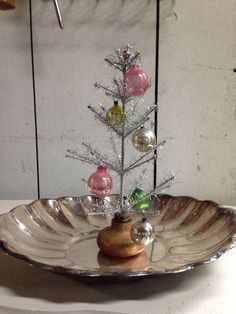 a small christmas tree in a silver bowl