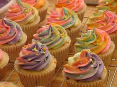 there are many cupcakes with different colored frosting