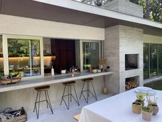 an outdoor bar with stools and tables in front of it