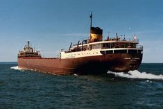 a large brown boat in the middle of the ocean