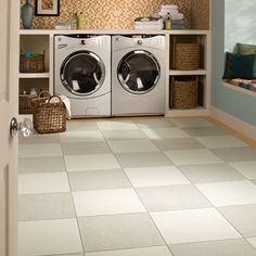 a washer and dryer in a room with tile flooring on the walls