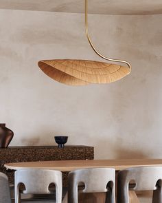 a dining room table with chairs and a wooden hanging light fixture over it's head