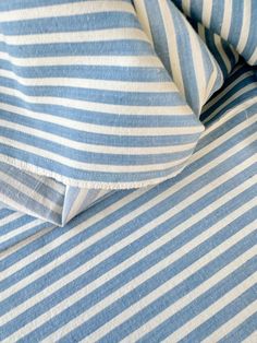 the blue and white striped sheets are folded together