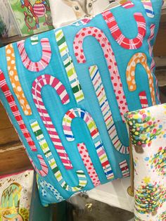 a decorative pillow is on display in a store with other colorful pillows and decorations behind it