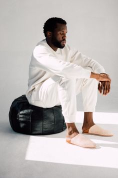 a man sitting on top of a black bag