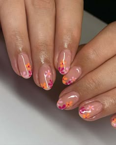 The nails feature a translucent base adorned with warm pink, vivid orange, and gentle lavender hues in a playful floral pattern. This cheerful design, reminiscent of a lively spring fling, showcases flowers that seem to dance and twirl with the season's energy. Click to see more and immerse yourself in this vibrant display.via@nailedbyvicx Pink Orange Nails, Spring Nail Art Ideas, Spring Nail Art Designs, Summer Holiday Nails, French Tip Gel Nails, Blush Pink Nails, Sunset Nails, Multicolored Nails