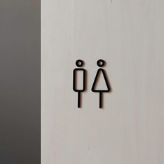 two black stickers on the side of a white door with a woman and man symbol