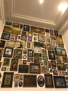 a wall covered in many different framed pictures