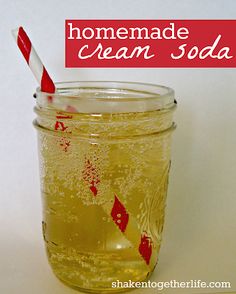 a glass filled with liquid sitting on top of a white counter next to a red and white striped straw