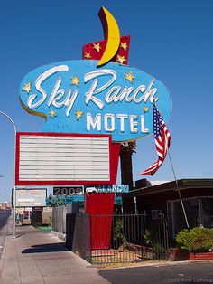 the sky ranch motel sign is painted red, white and blue