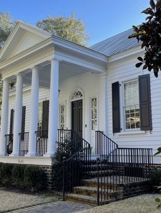 a white house with columns and black shutters