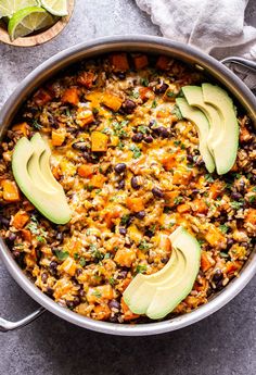 a pot filled with black bean and rice, avocado slices on the side