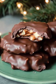 chocolate covered cookies on a green plate with christmas lights in the background