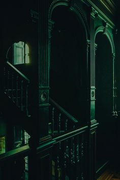 a dark room with wooden floors and railings