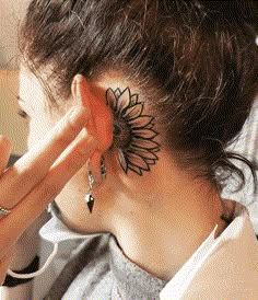 a woman with a sunflower tattoo on her ear