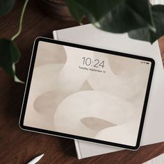 an ipad sitting on top of a wooden table next to a white plate and knife