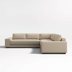 a beige sectional couch sitting on top of a white floor