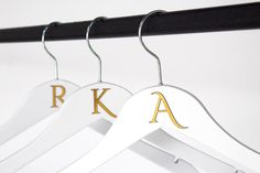 two white hangers with gold letters on them