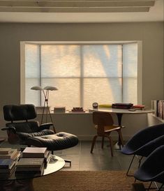 a living room filled with furniture next to a window covered in blind shades on the windowsill