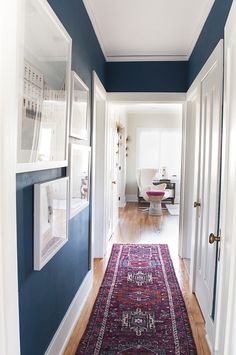 the hallway is painted blue and has a rug on the floor in front of it