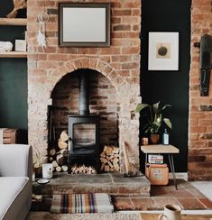 a living room filled with furniture and a fire place in front of a brick fireplace