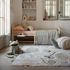 a child's bedroom with white walls and flooring, including a rug on the floor