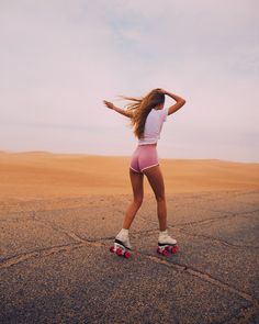 a woman riding roller skates across a desert