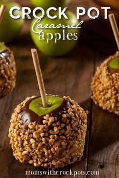 an apple covered in nuts and caramel is sitting on a wooden table with the words crock pot caramel apples