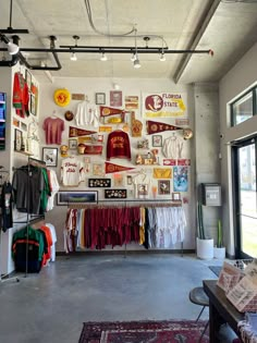 the inside of a clothing store with lots of items hanging on the wall and pictures on the wall