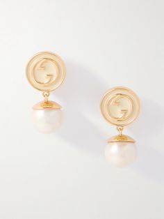 Gucci’s ‘Blondie’ earrings are brimming with vintage charm. Made in Italy from gold-tone metal, they're decorated with glossy enamel featuring the signature interlocking 'GG' motif. Lustrous faux-pearl pendants dangle from the base. Gucci Pearl Earrings, Gucci Luxury Drop Earrings, Designer Gold Drop Pearl Earrings, Designer Gold Pearl Drop Earrings, Vintage Gold Gucci Jewelry, Vintage Gucci Gold Jewelry, Elegant White Jewelry With Logo Charm, Vintage Gucci Jewelry For Formal Occasions, Vintage Gucci Jewelry For Formal Events